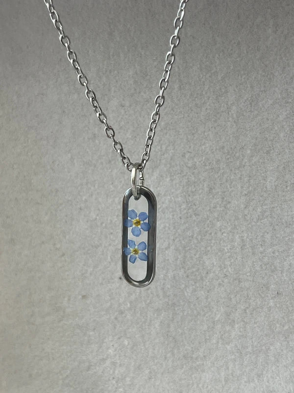 Collier médaillon ovale fond transparent myosotis, argenté