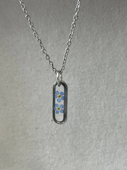 Collier médaillon ovale fond transparent myosotis, argenté
