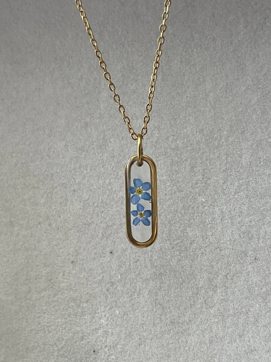 Collier médaillon ovale fond transparent myosotis, doré