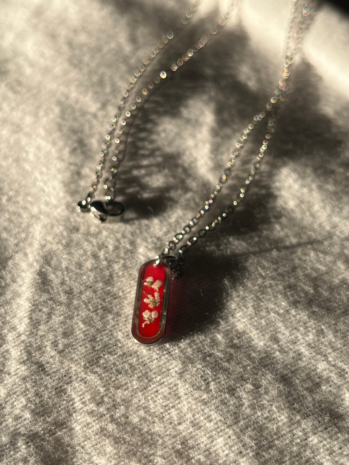 Collier ovale fond rouge