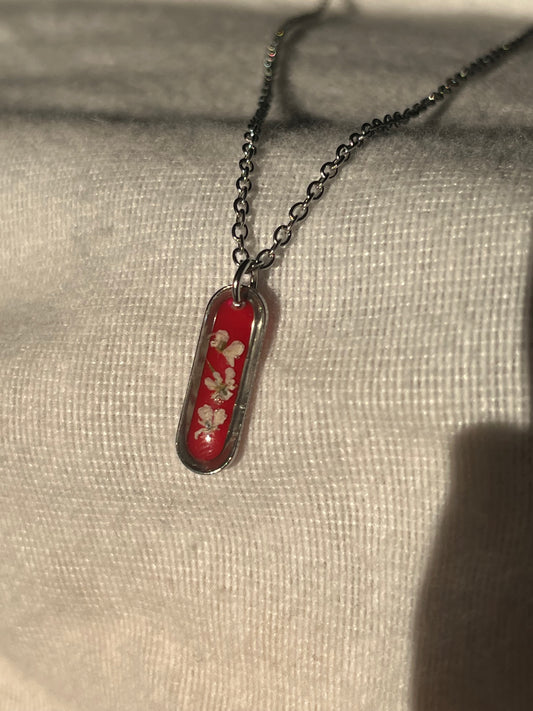Collier ovale fond rouge
