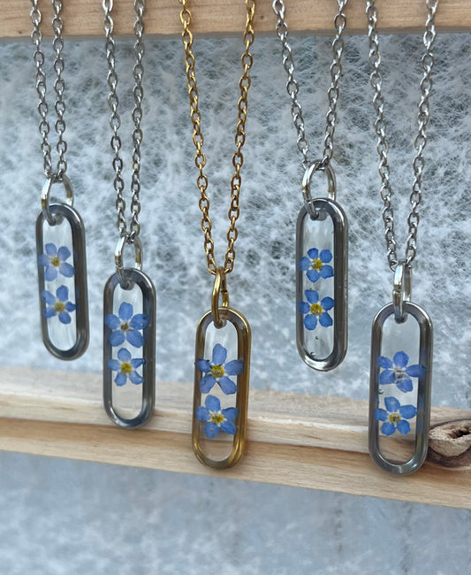 Collier médaillon ovale fond transparent myosotis, argenté
