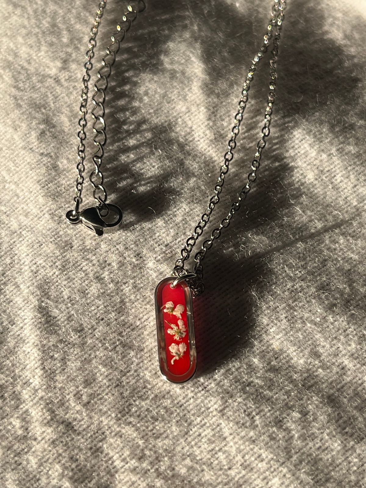 Collier ovale fond rouge
