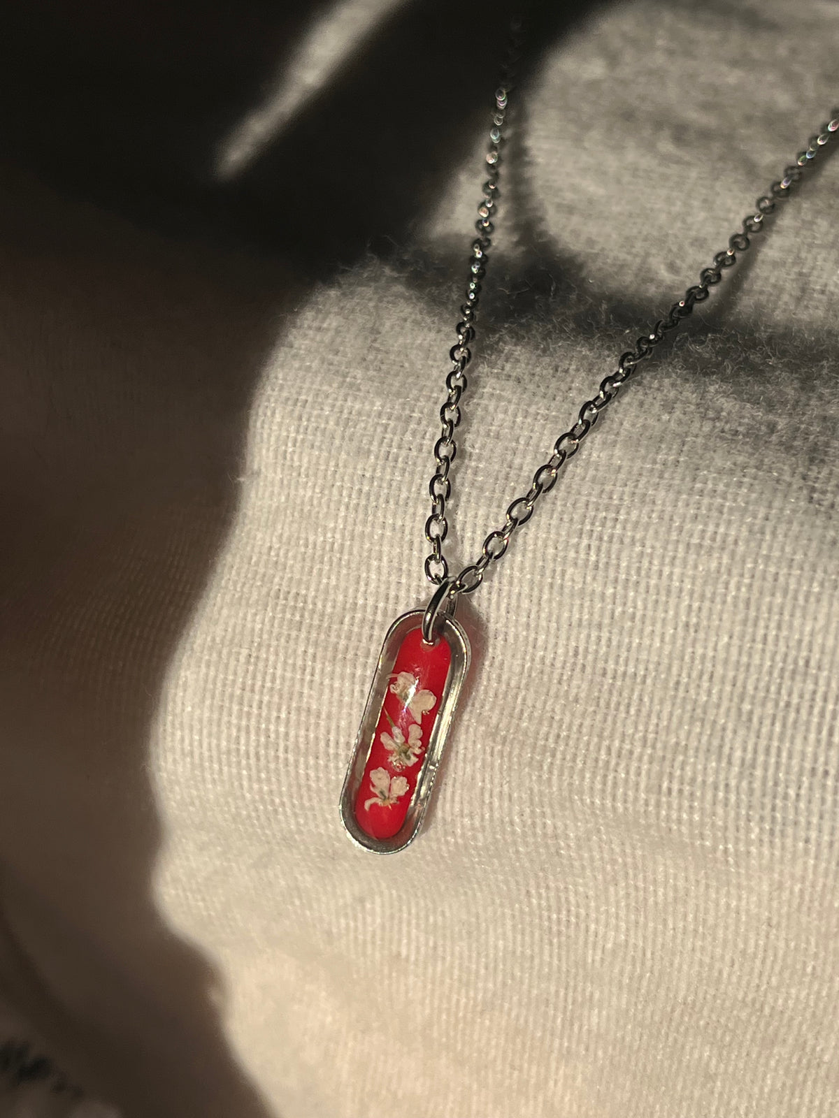 Collier ovale fond rouge